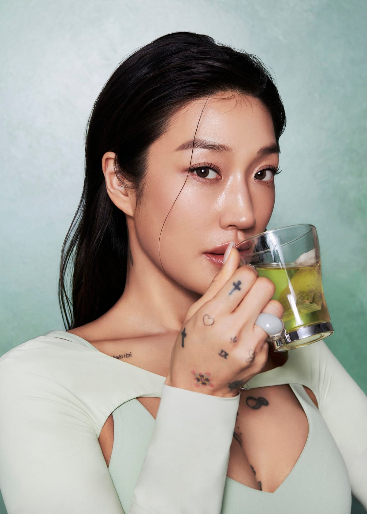 a woman holding a glass of liquid