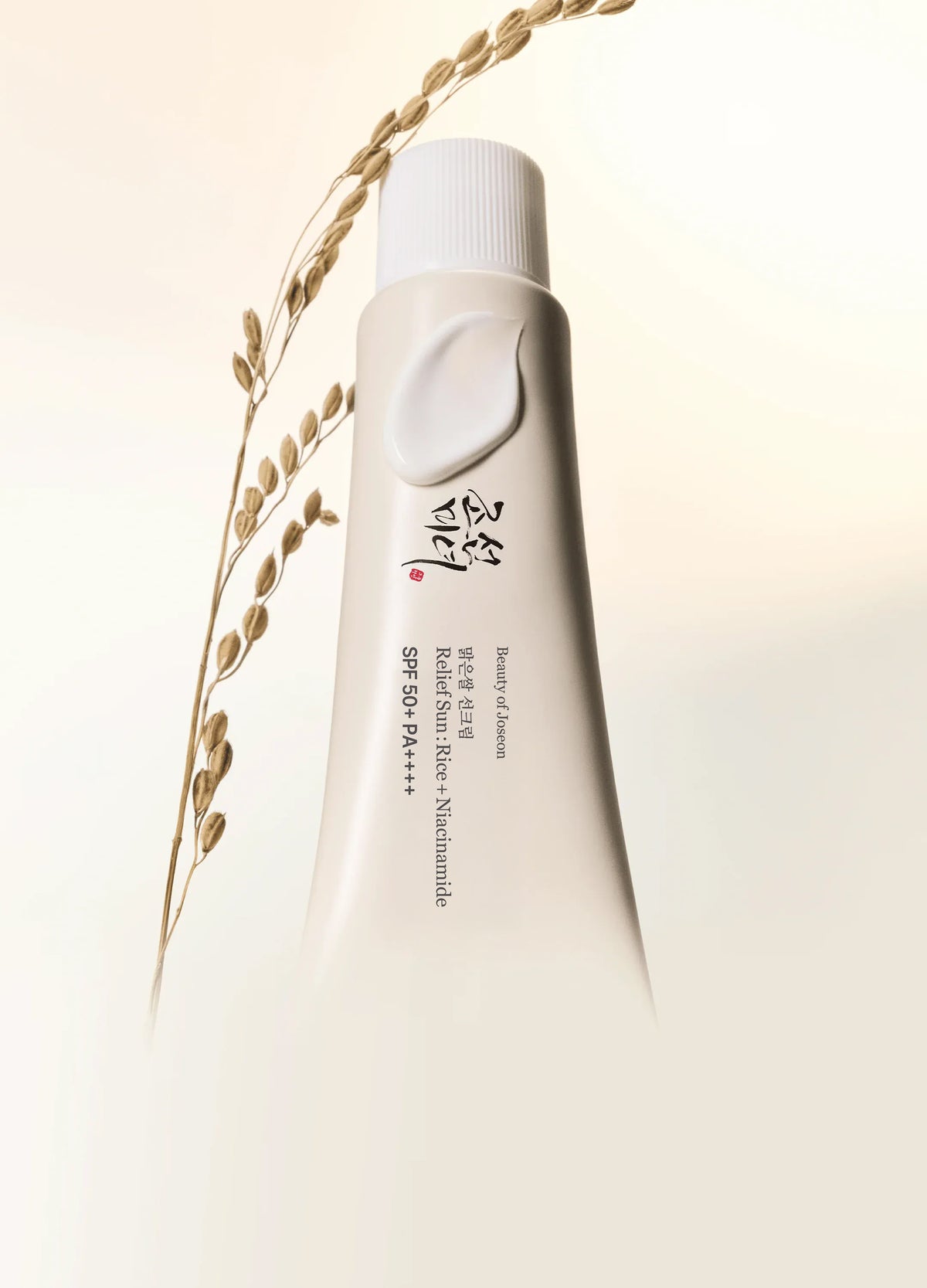 a white tube with a cap and a plant