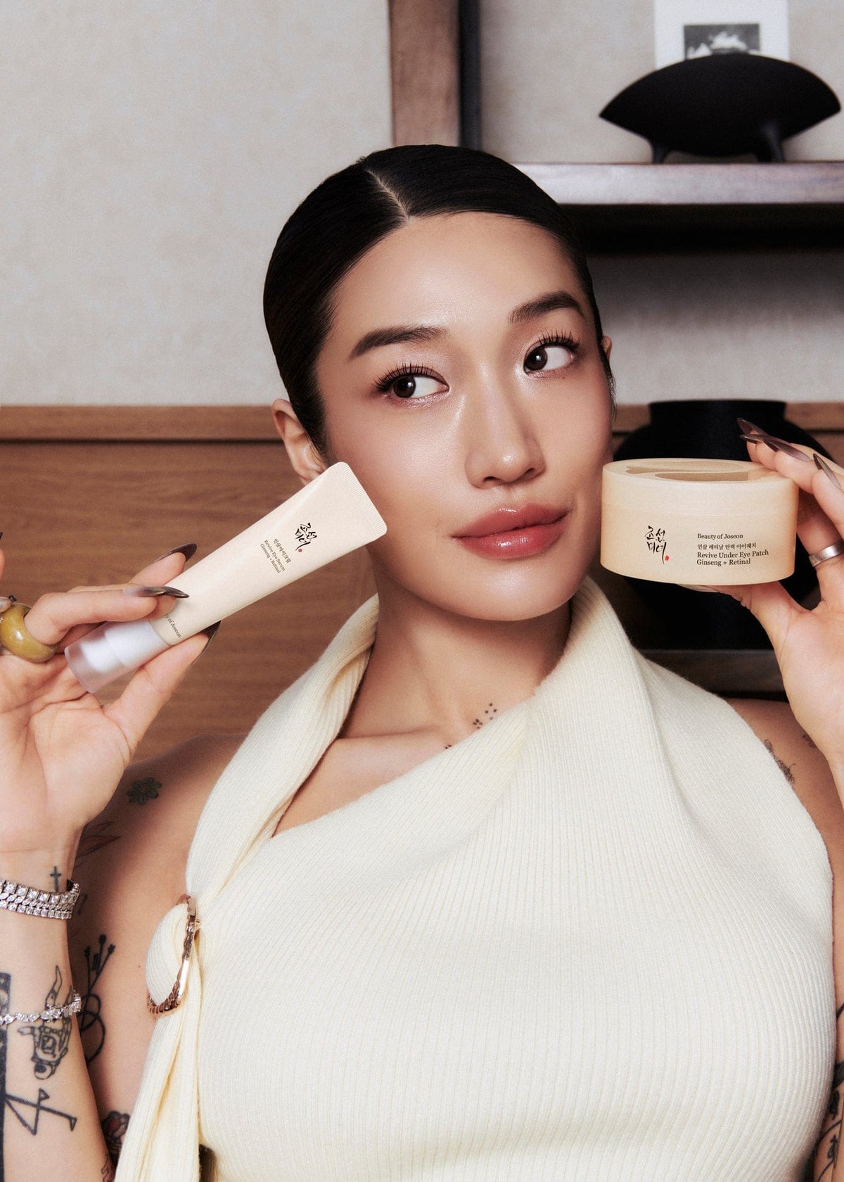 a woman holding a cream tube and a tube of cream