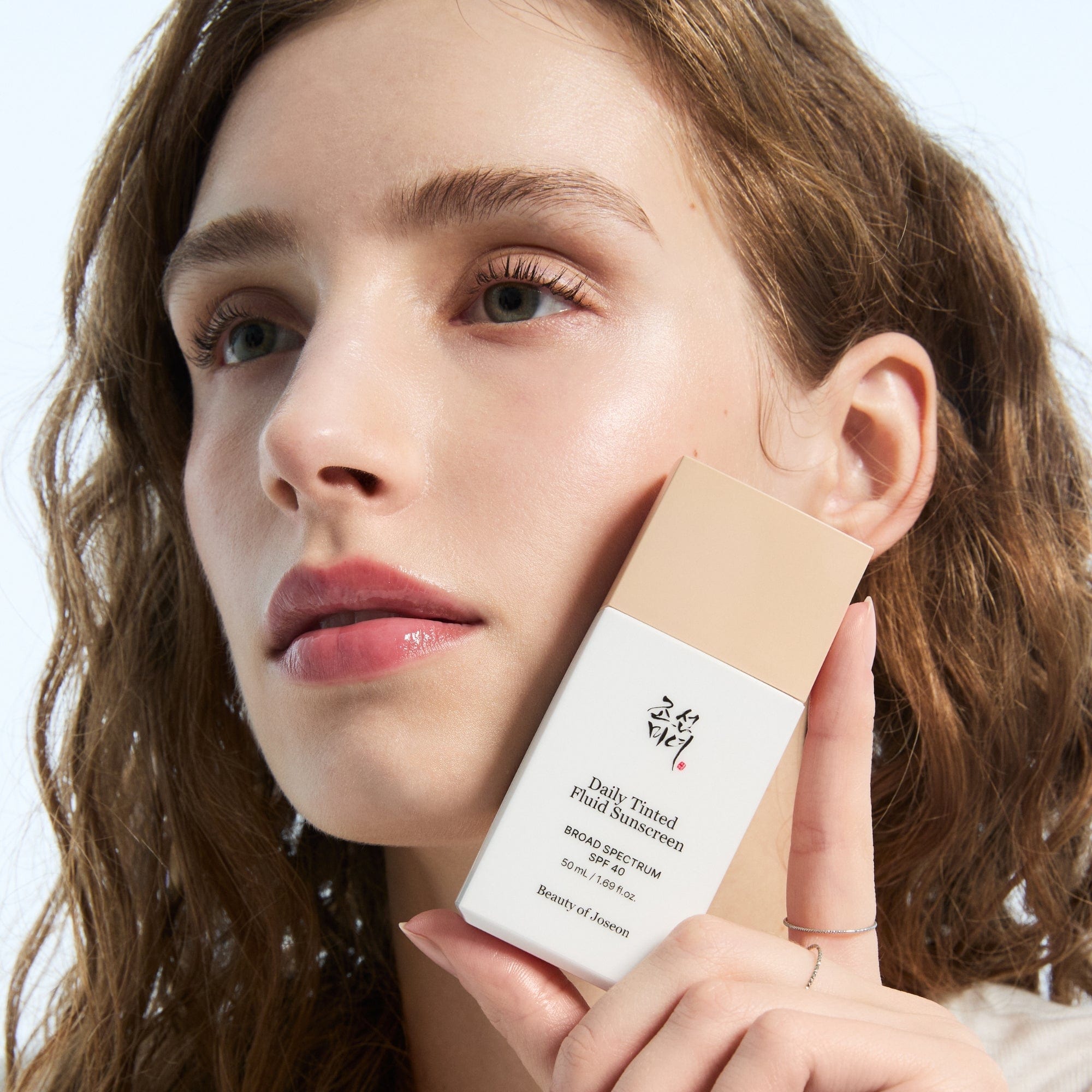 a woman holding a box of makeup