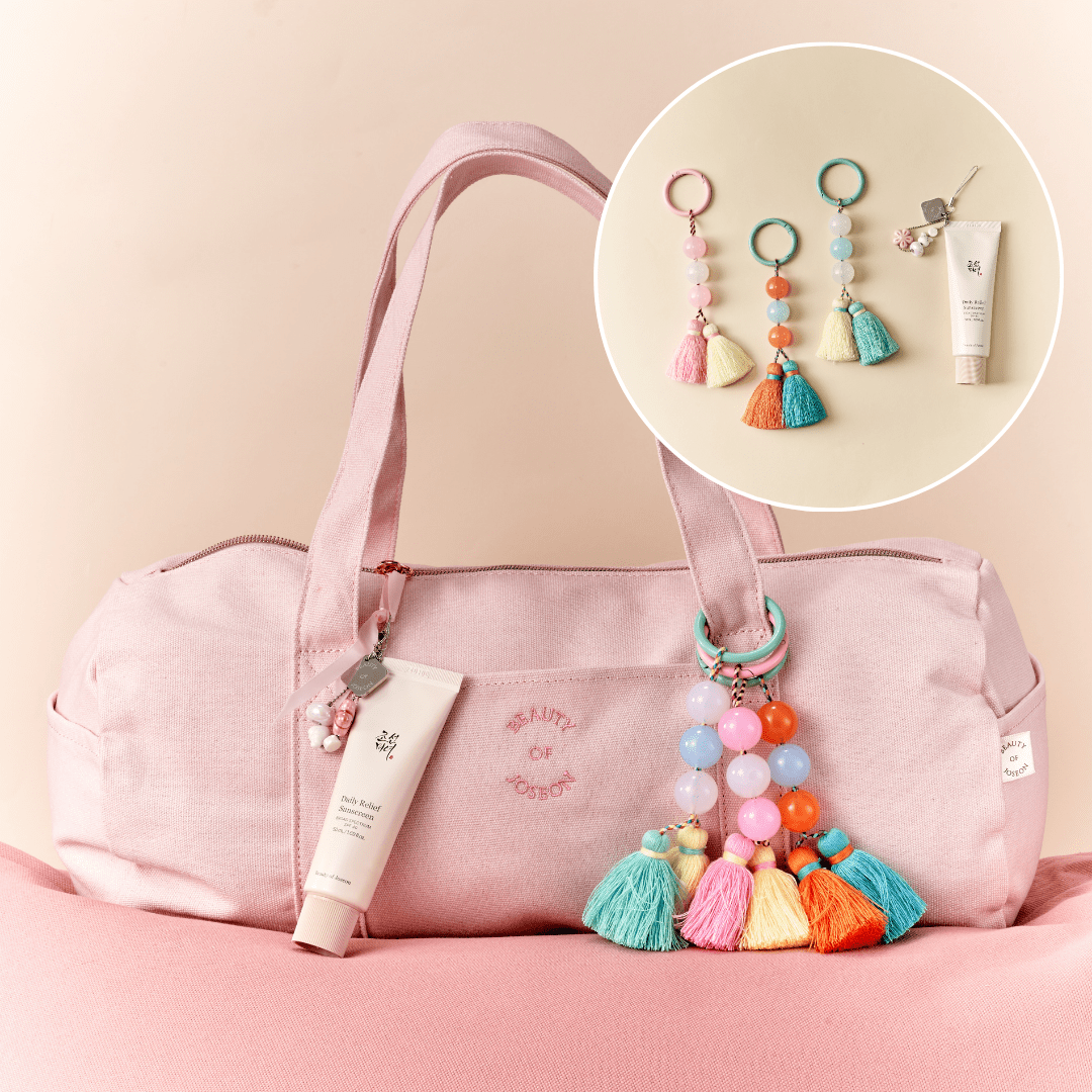 a pink bag with tassels and keychains