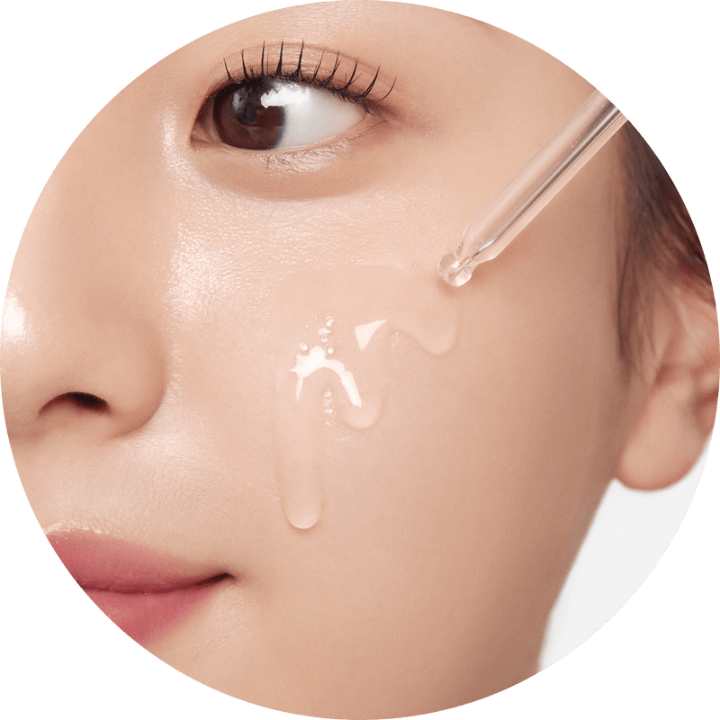 a woman dripping liquid onto her face