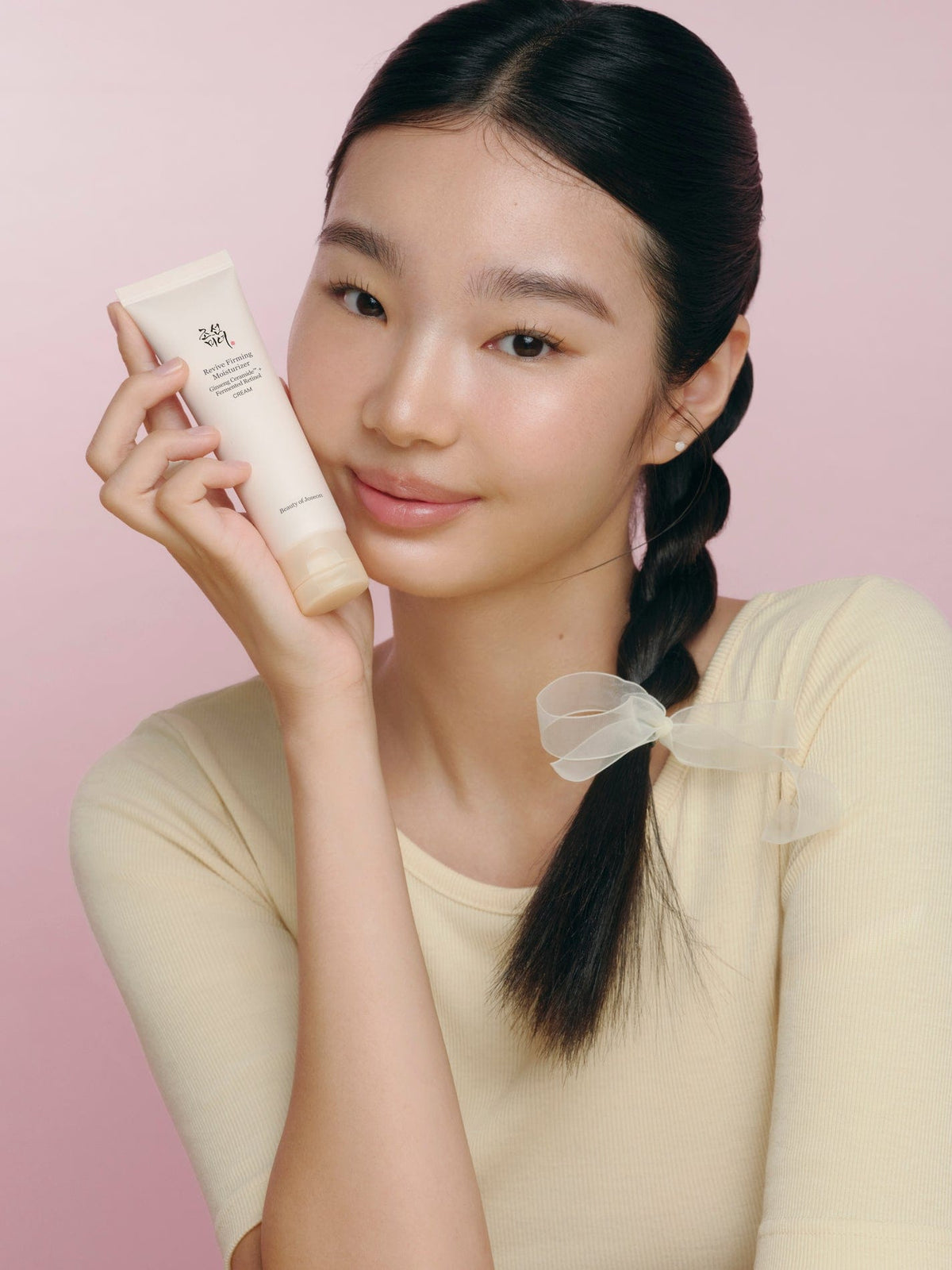a woman holding a tube of cream