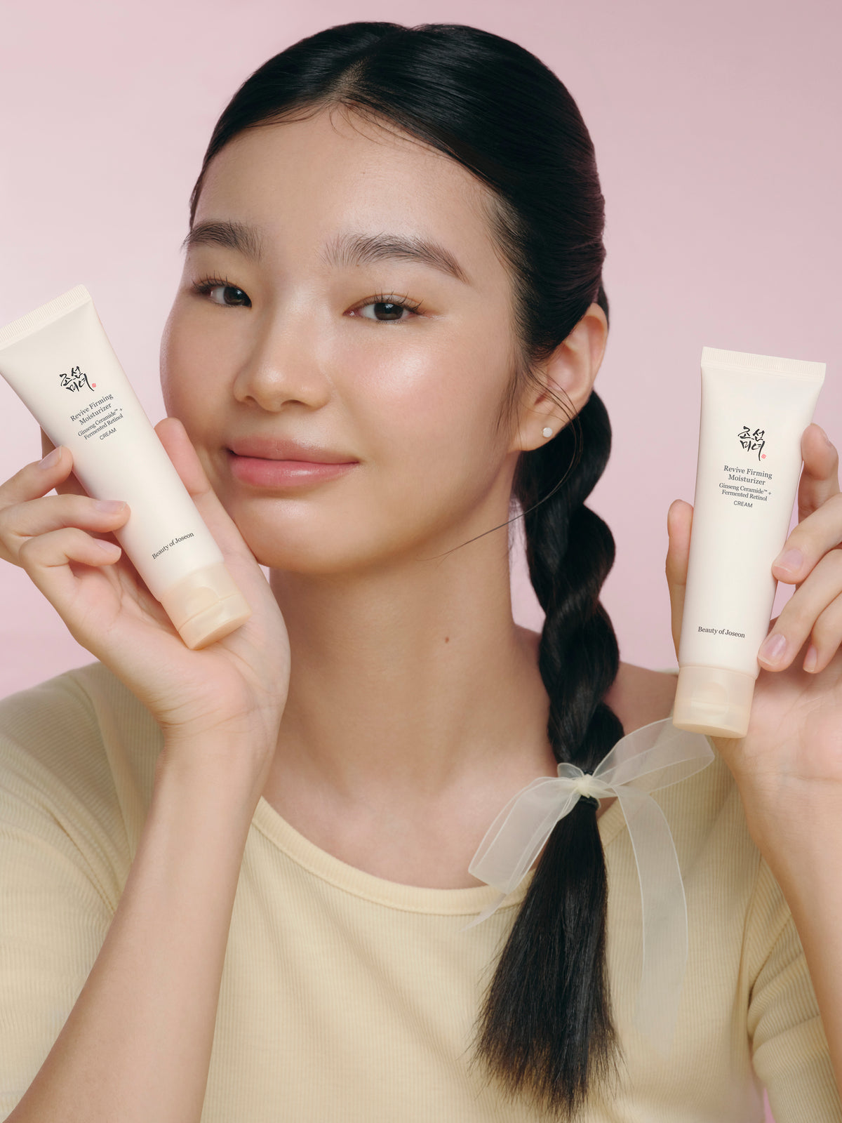a woman holding two bottles of cream