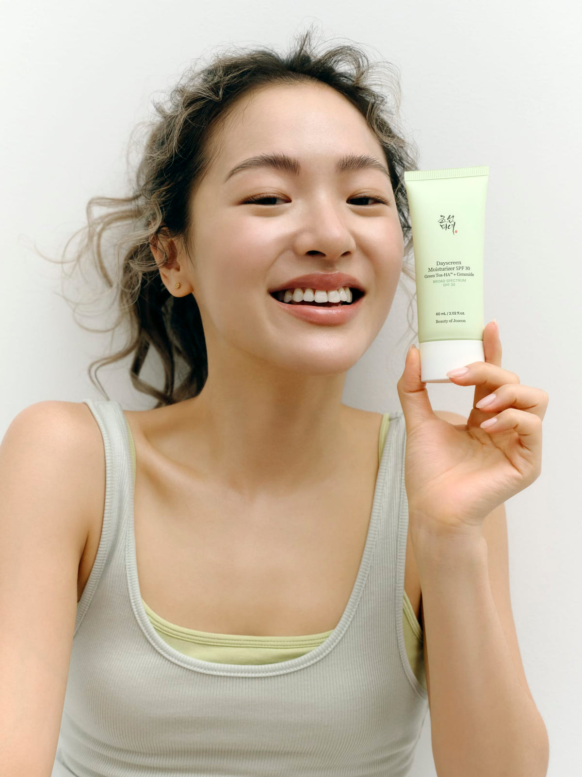 a woman holding a tube of cream