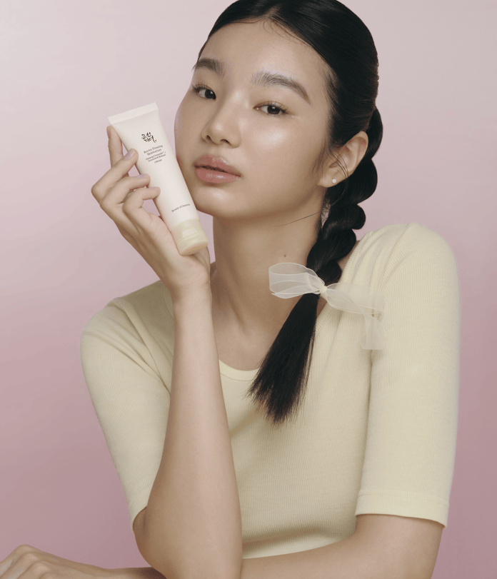 a woman holding a tube of cream