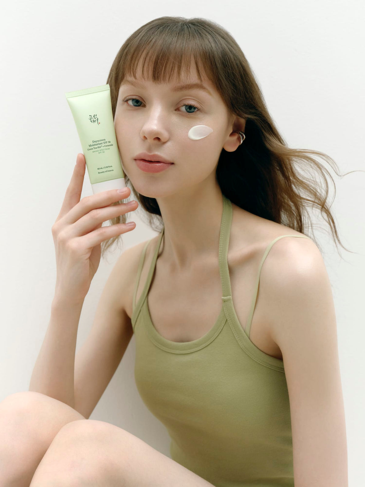 a woman holding a tube of cream
