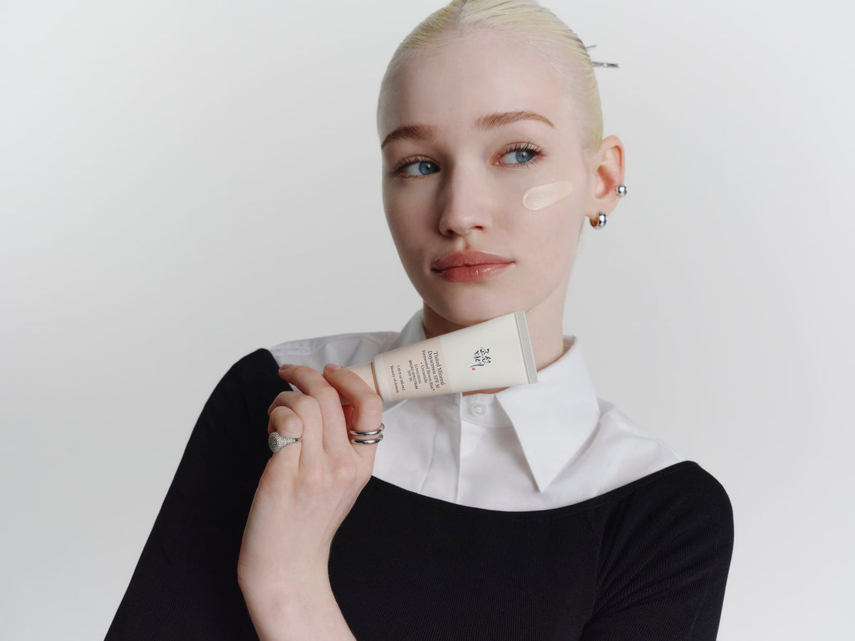 A model holding a Tinted Mineral Dayscreen product.