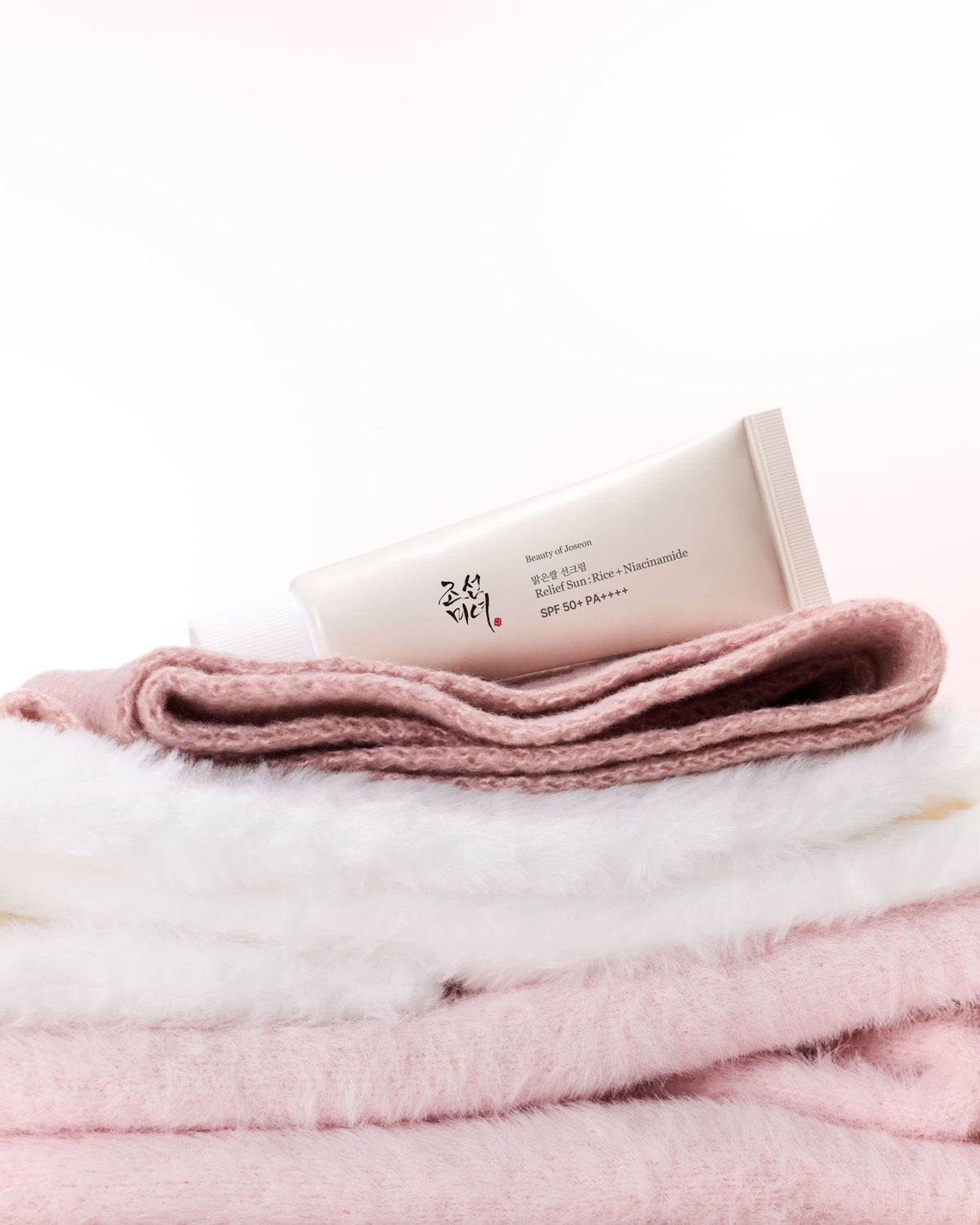 a tube of cream on a pile of blankets
