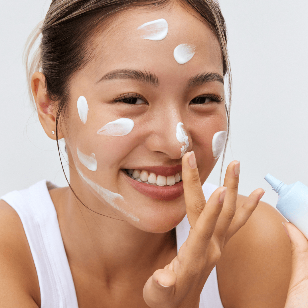 a woman applying cream on her face