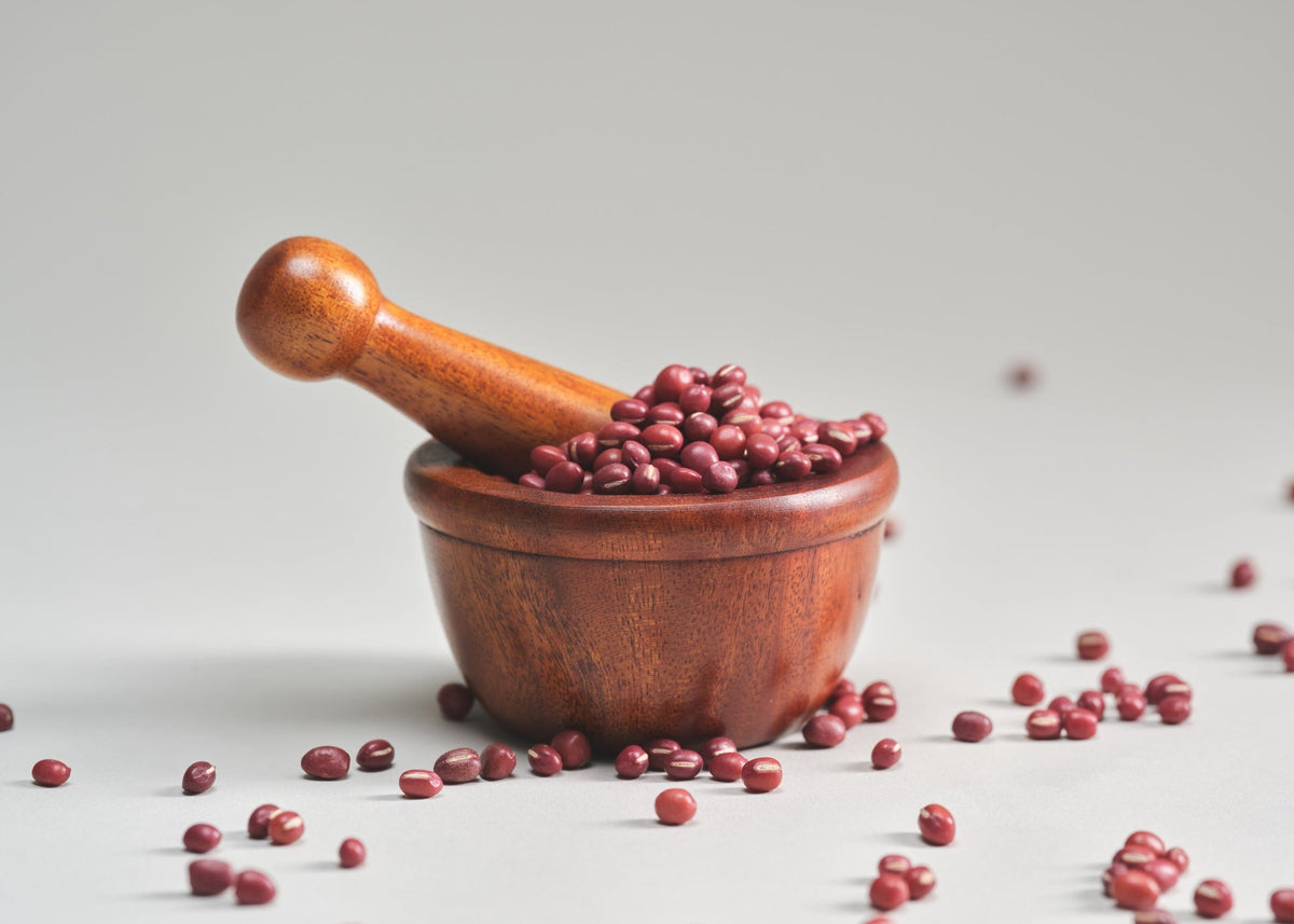 a mortar and pestle with red beans