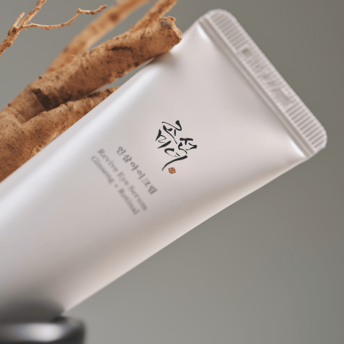 a white tube of cream next to a plant