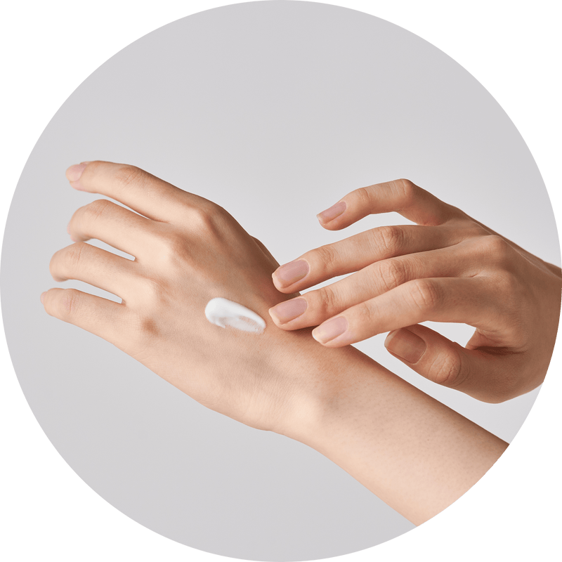 a close-up of hands applying cream