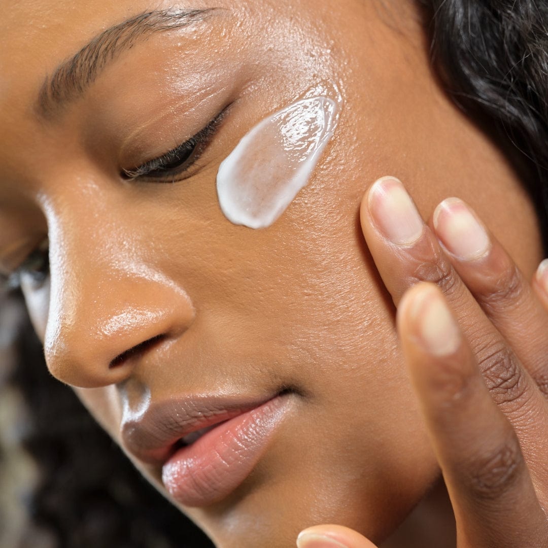 a woman applying a cream on her face