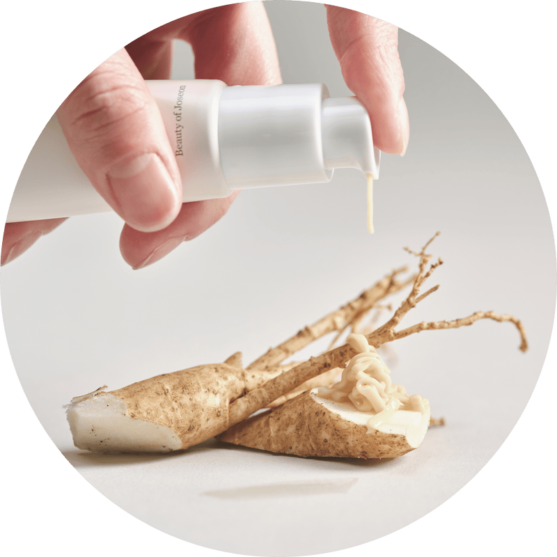 a hand holding a white bottle over a root