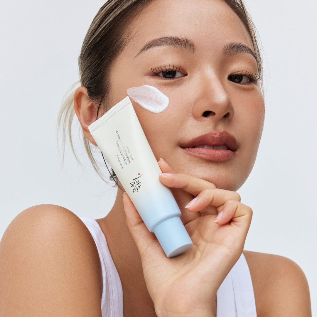 a woman holding a tube of cream