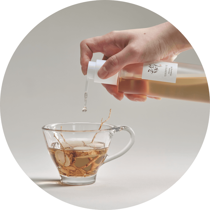 a hand pouring liquid into a cup of tea