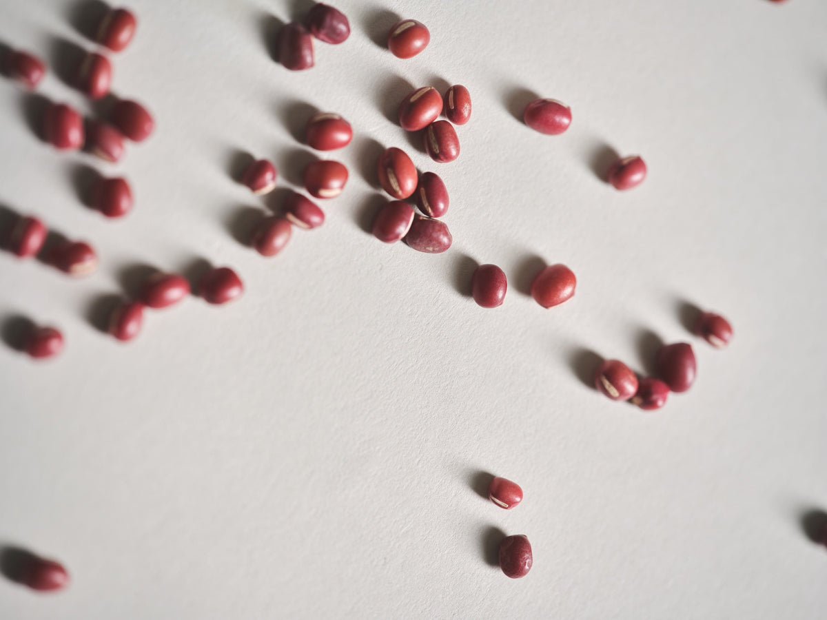 a group of red beans on a white surface