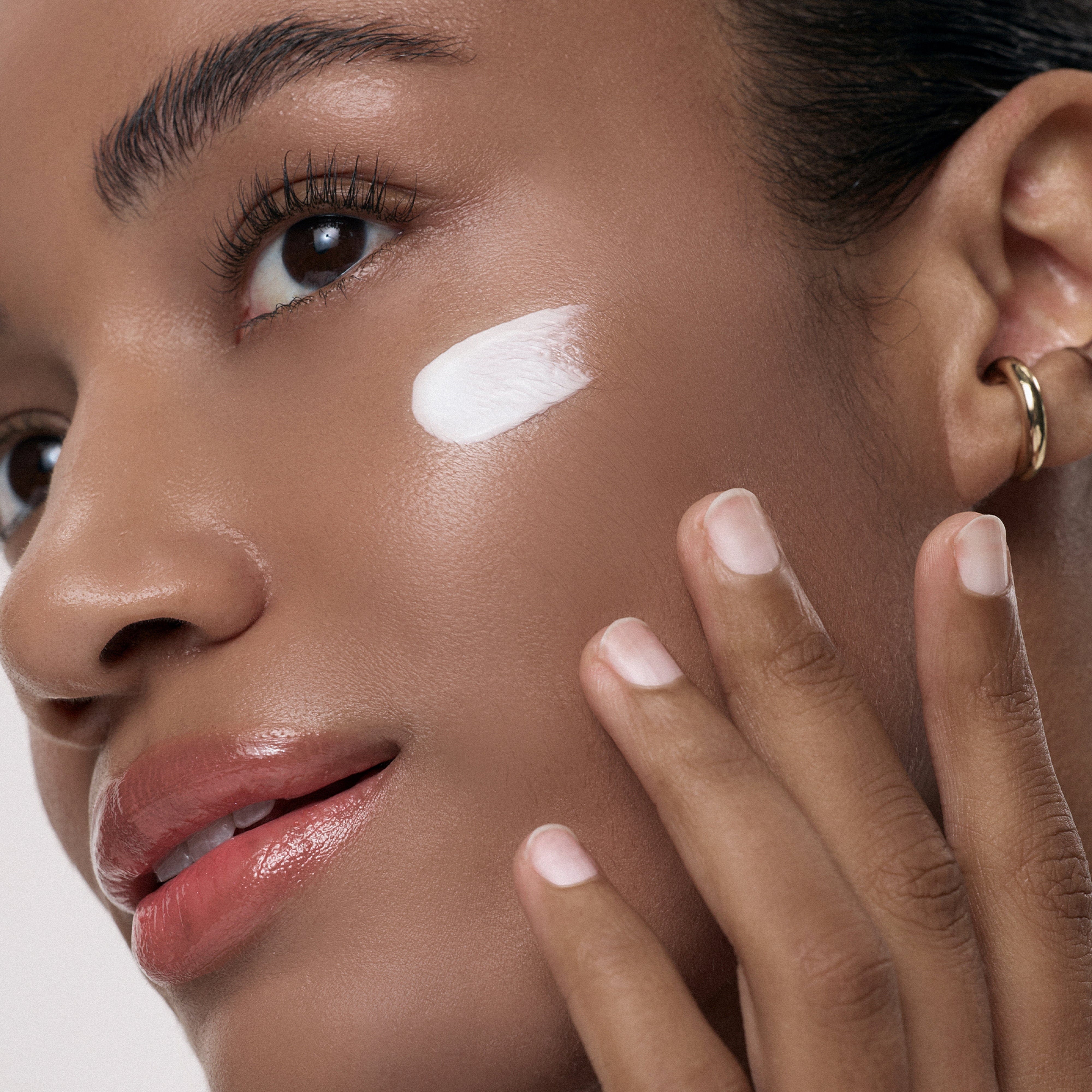 a woman applying cream on her face
