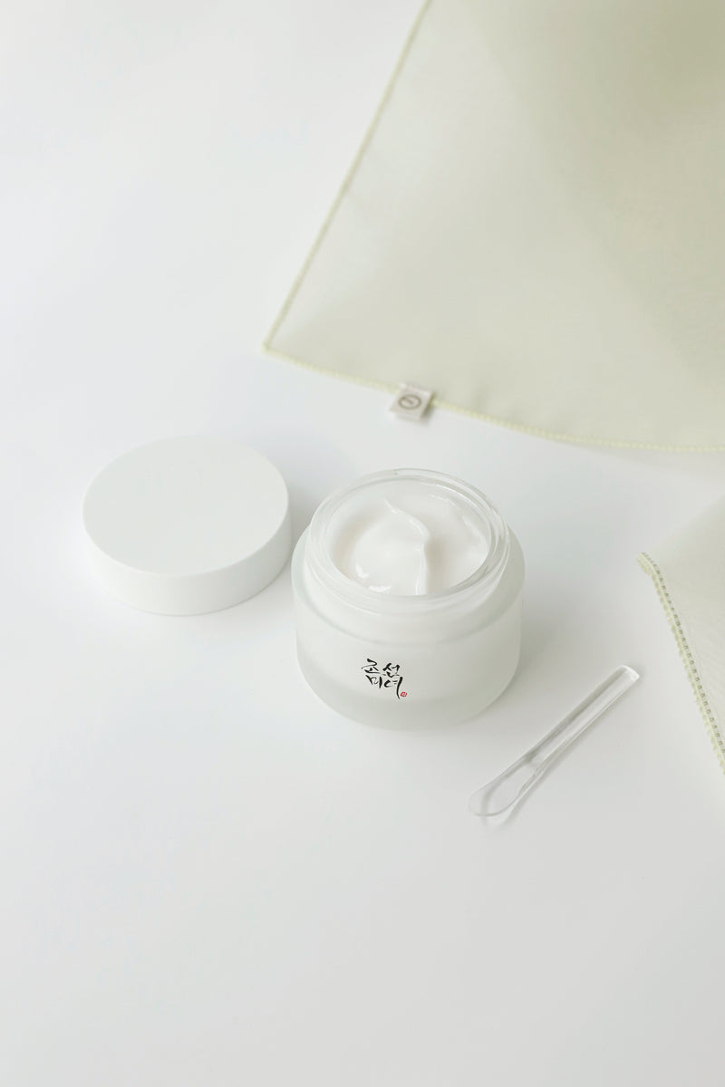 a jar of cream next to a tweezers