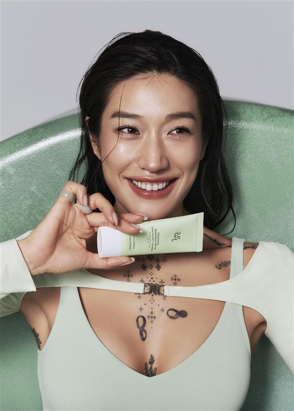 a woman holding a tube of cream
