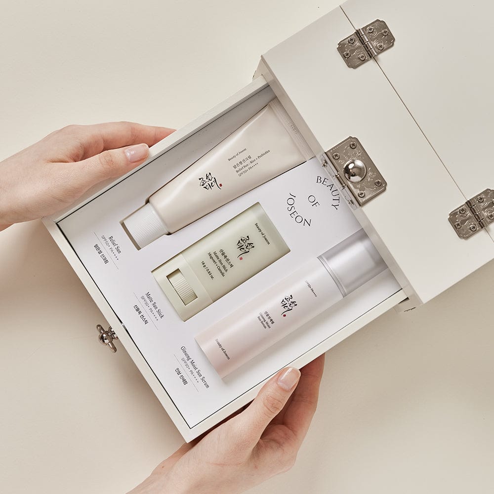a hand holding a box with a set of cosmetics