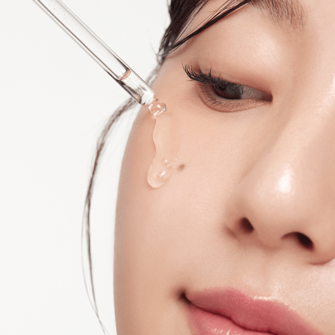 a woman dripping a drop of liquid into her eye