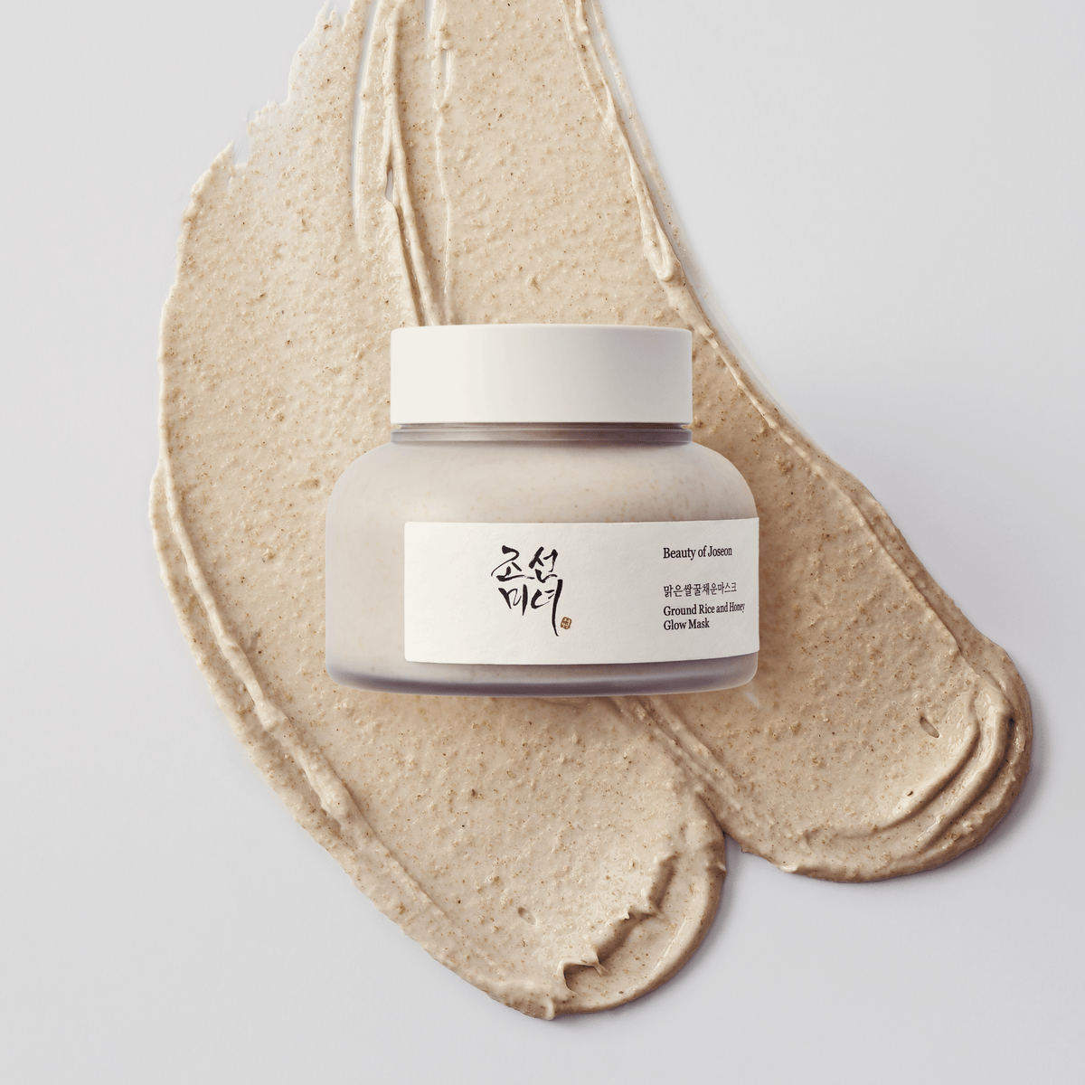 a jar of face cream on a blot of brown liquid