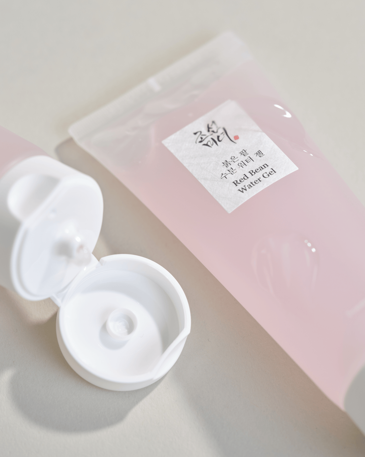 a plastic bottle of gel next to a plastic container