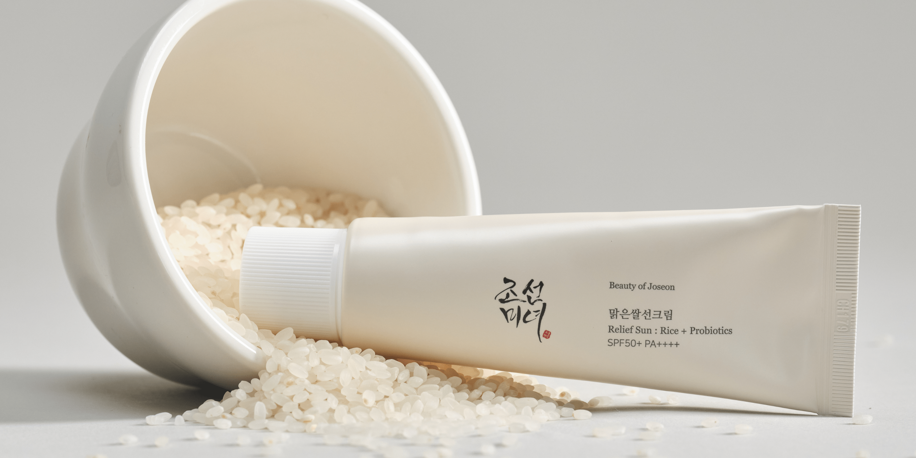 a white container with a tube of cream and rice