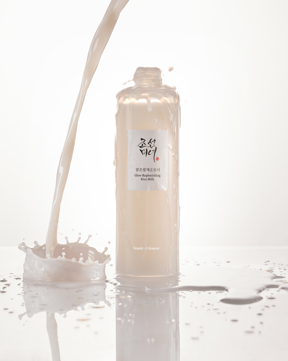 a bottle of liquid pouring into a splash