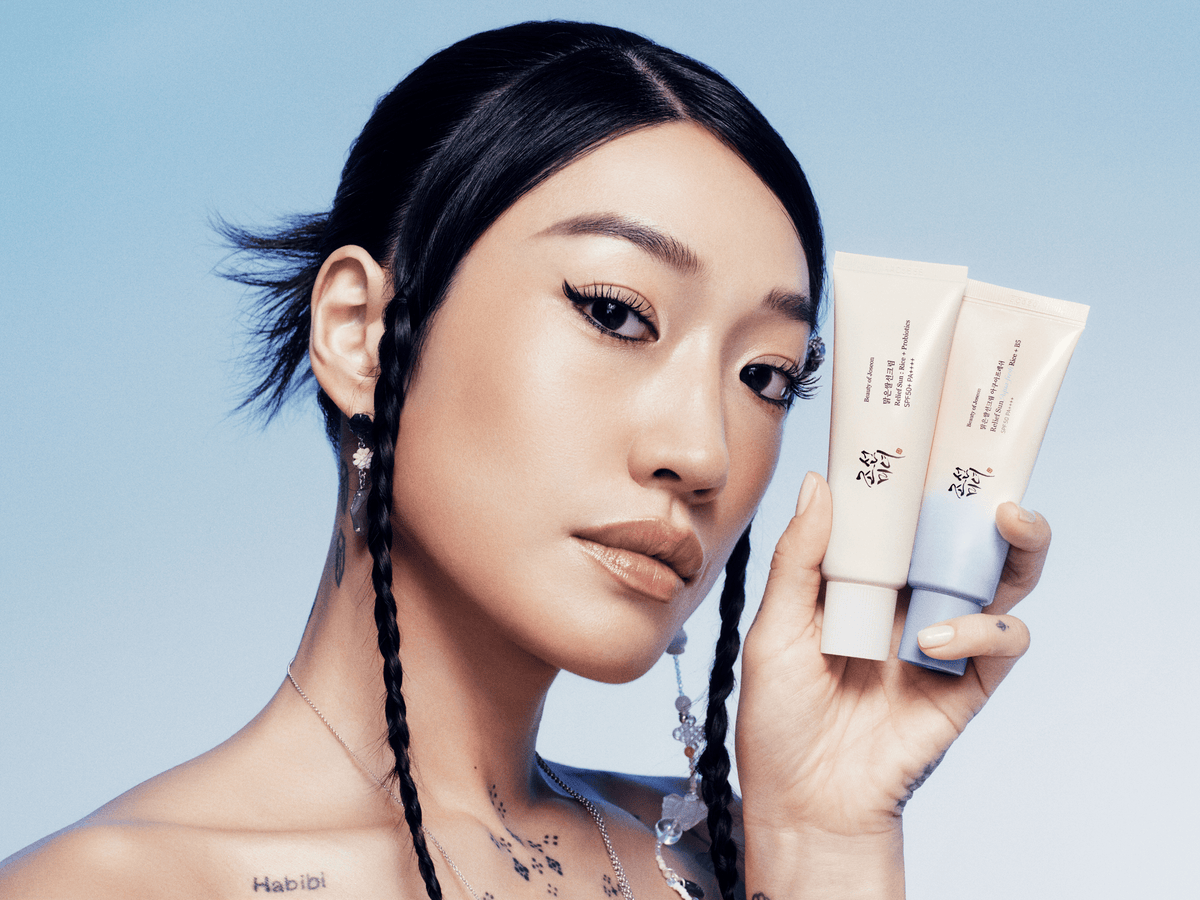 a woman holding two tubes of cream
