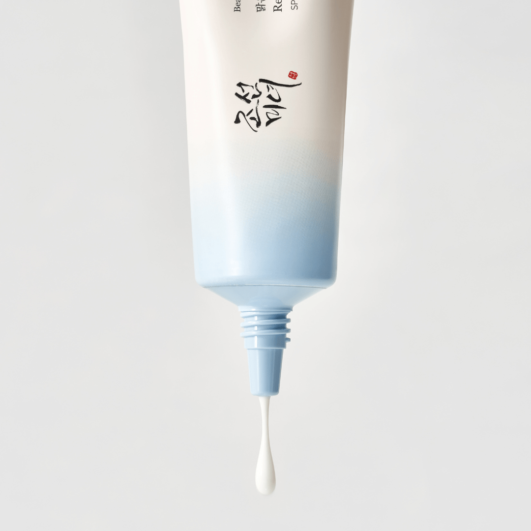 a white and blue container with a drop of liquid