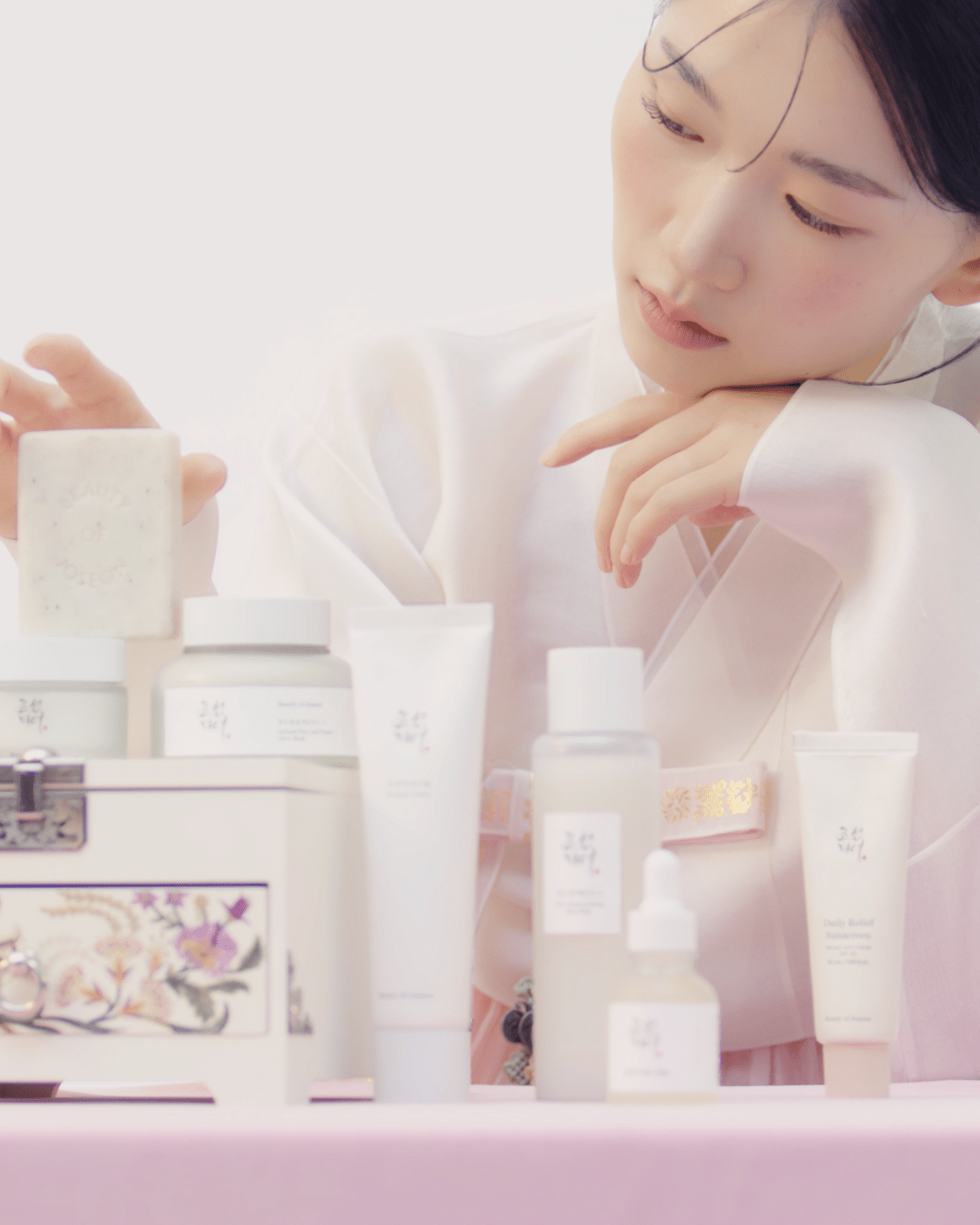 a woman looking at a box of cosmetics