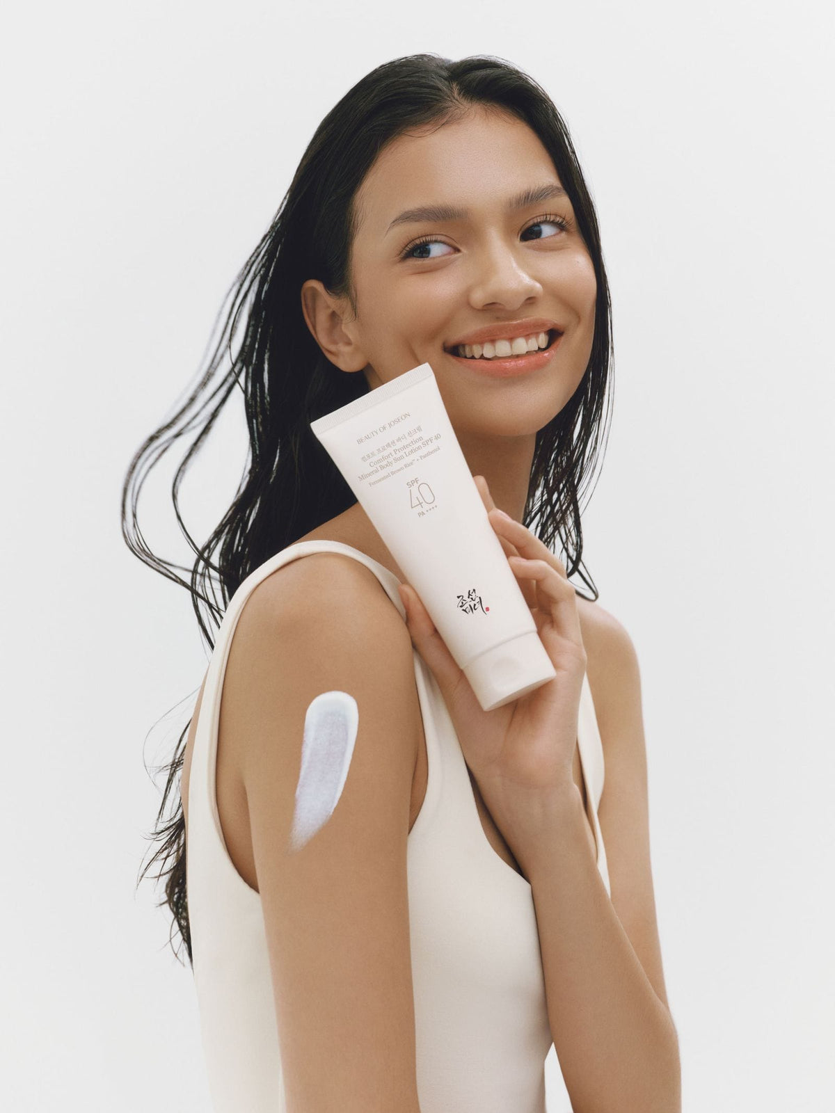 a woman holding a tube of cream