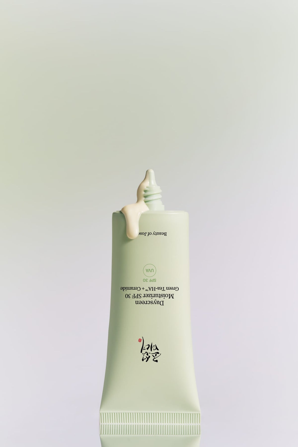 a white bottle with a drop of cream on top