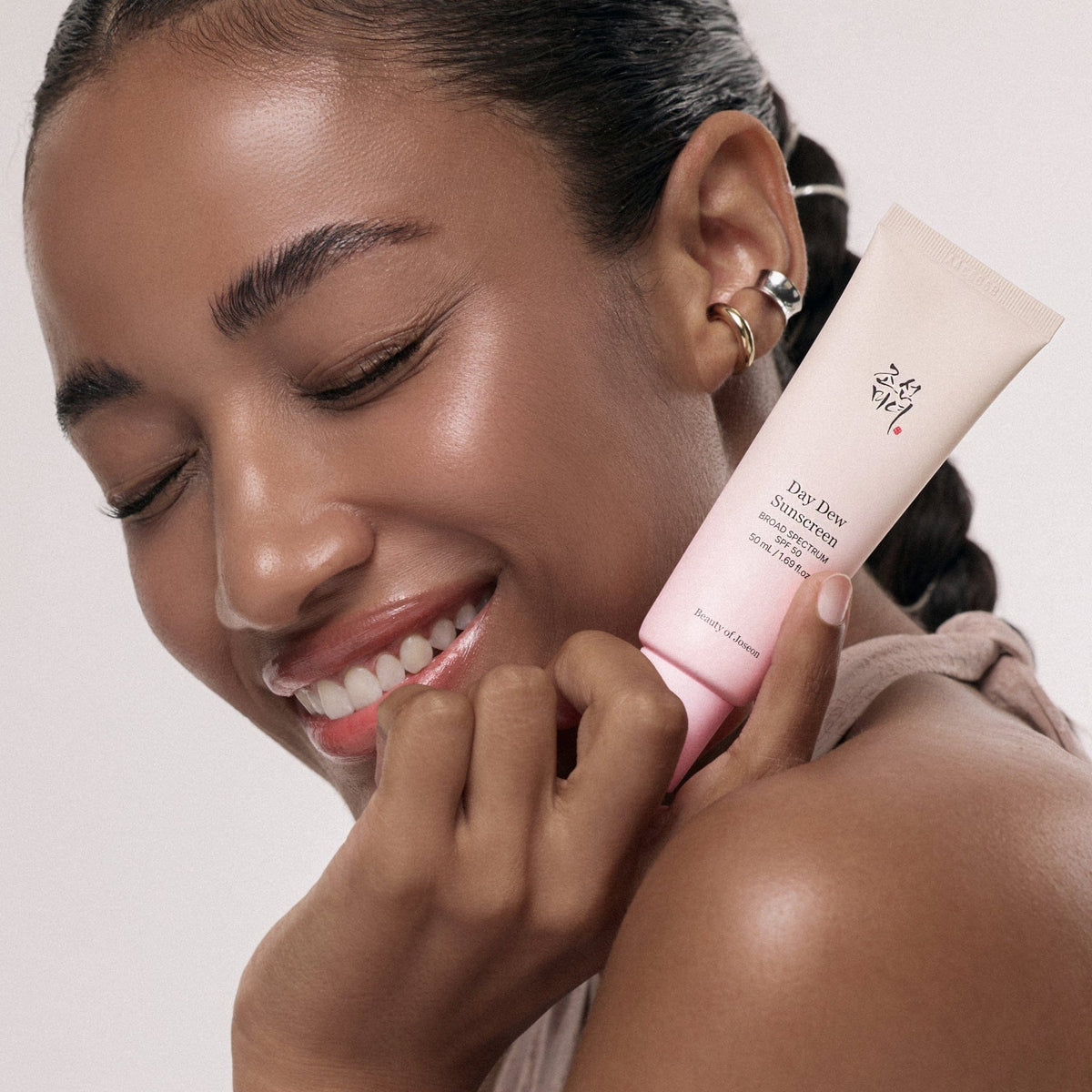 a woman holding a tube of cream