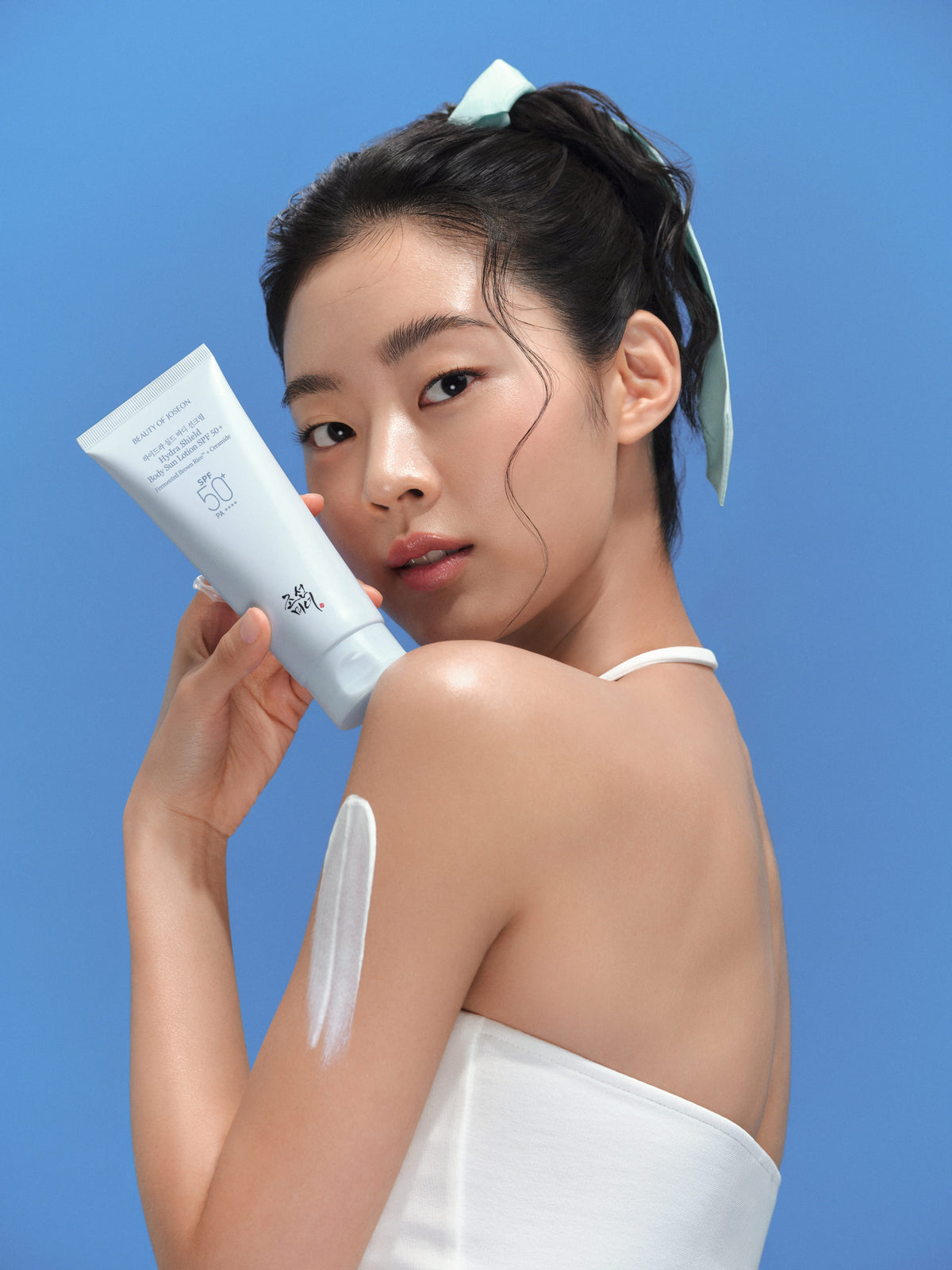 a woman holding a tube of cream
