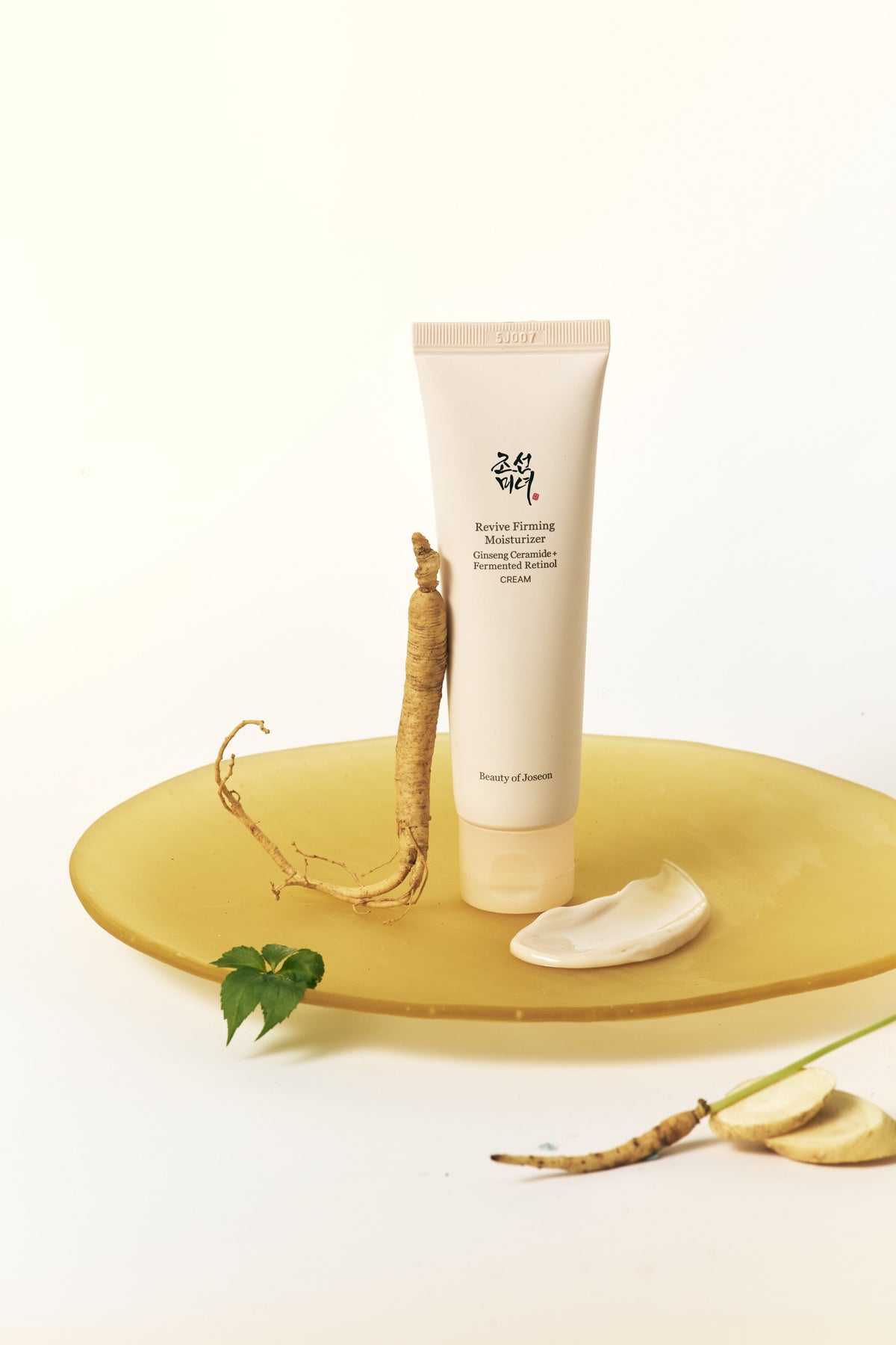 a white tube of cream next to a root on a yellow plate