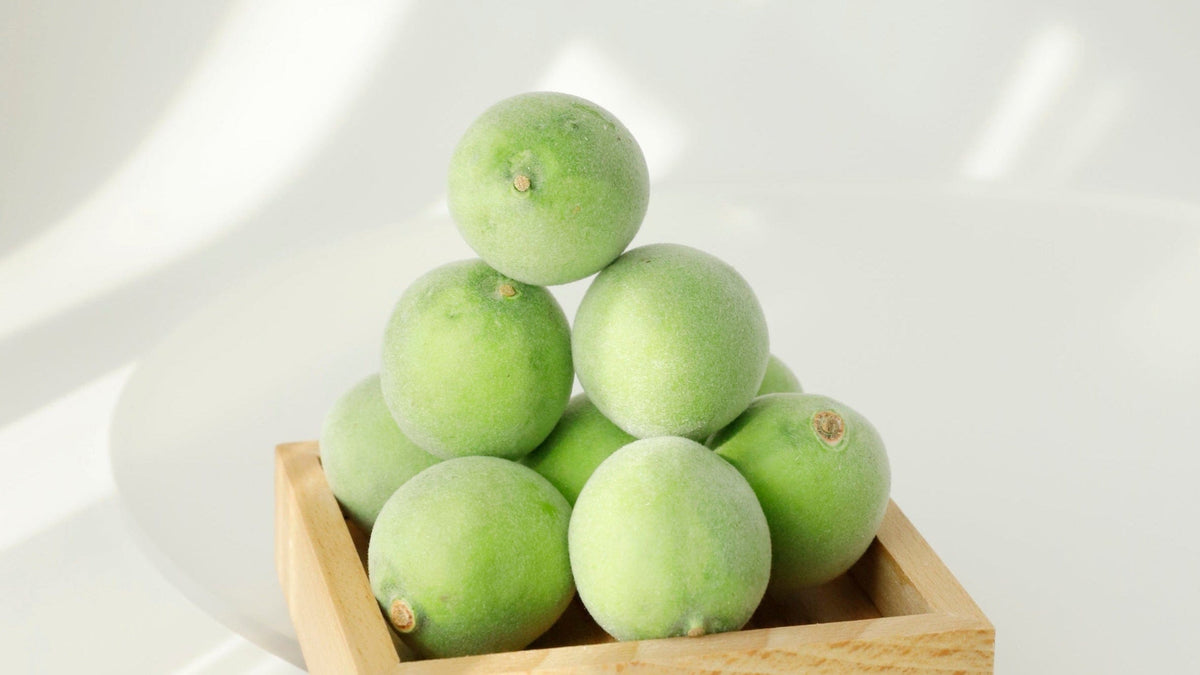 a group of green fruit in a wooden bowl