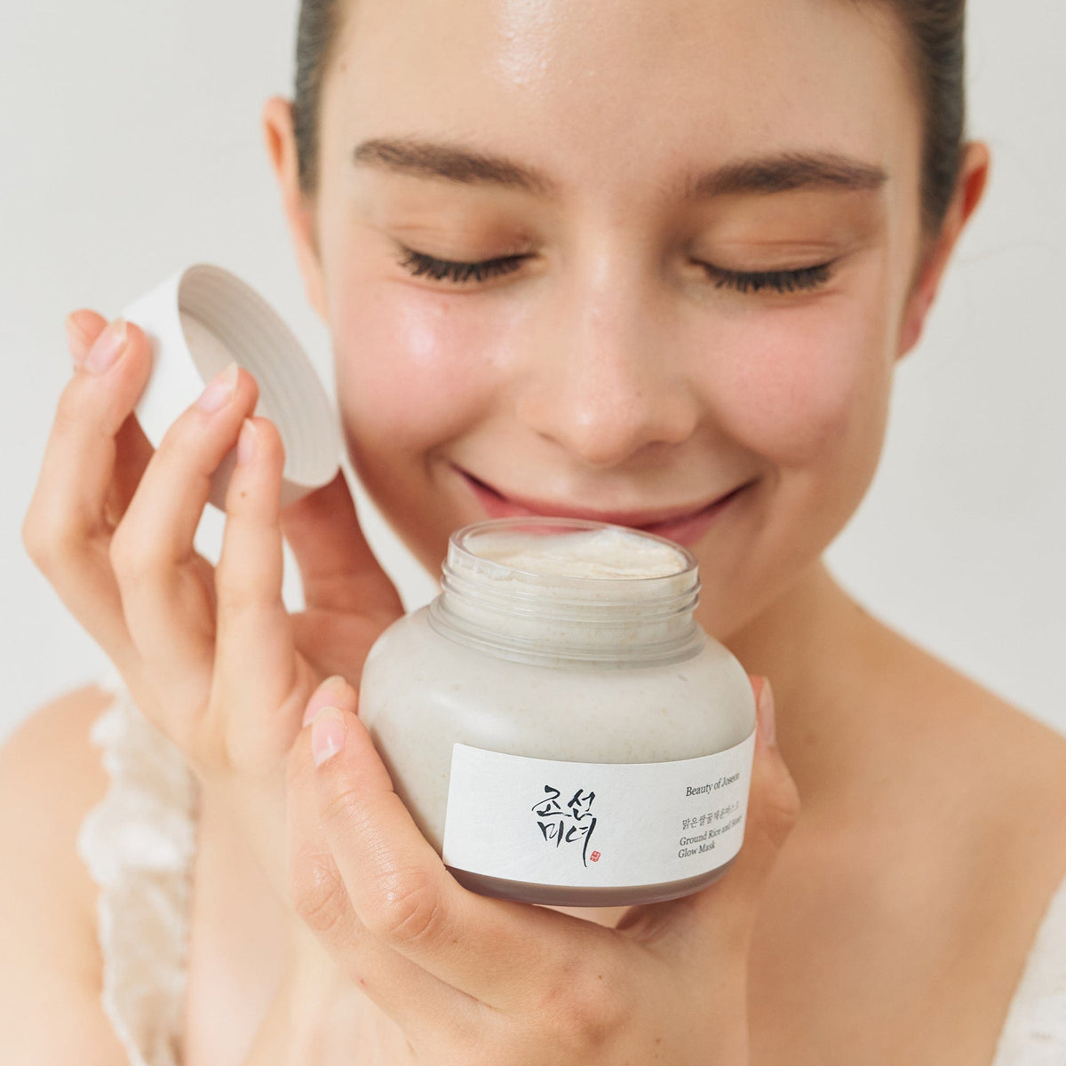 a woman holding a jar of cream