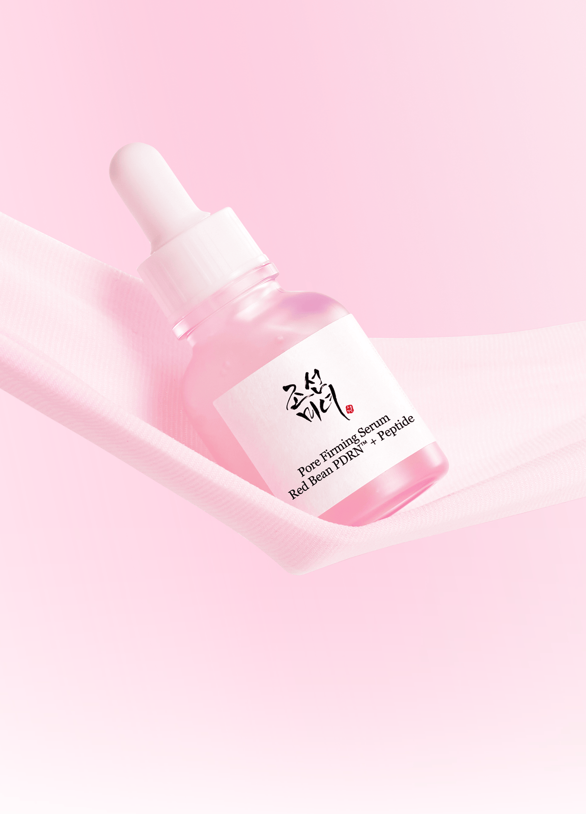 a pink bottle with a dropper on it