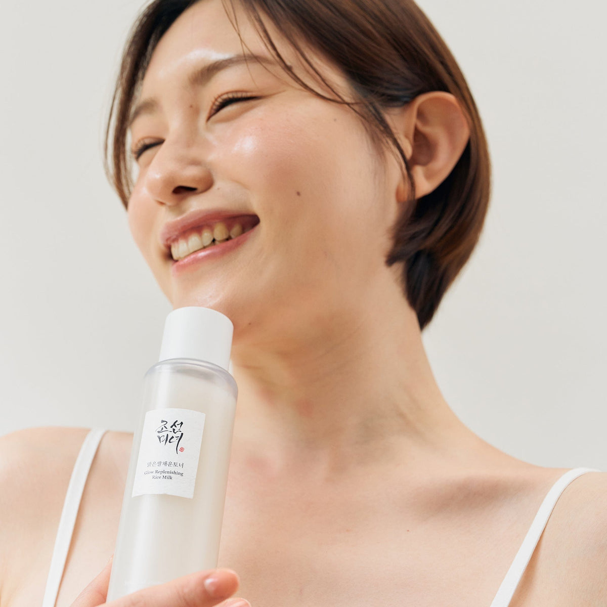 a woman holding a bottle of shampoo