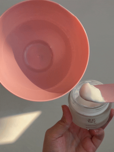 a person holding a jar of white cream