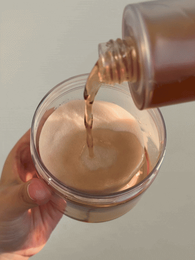 a person pouring liquid into a glass