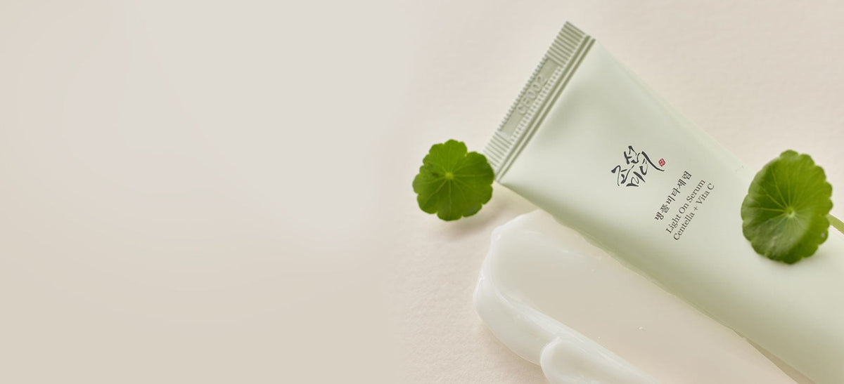 a white tube with a green leaf next to it